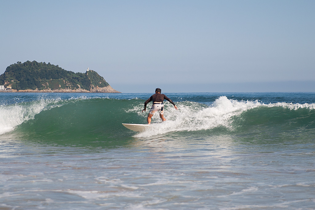 Angel Unzueta haciendo surf en la playa de Zarautz con prendas de PUKAS.